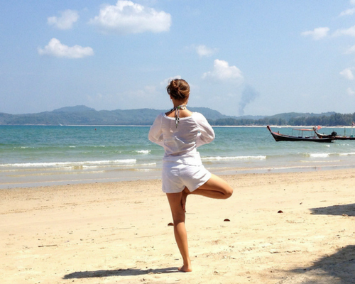 image of a woman doing yoga on the beach